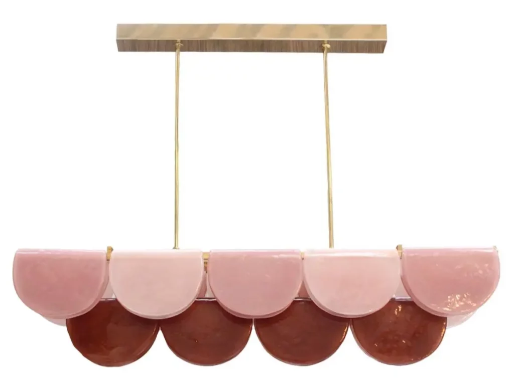 Elongated pink red multicoloured Murano glass chandelier with brass frame in modern interior.
